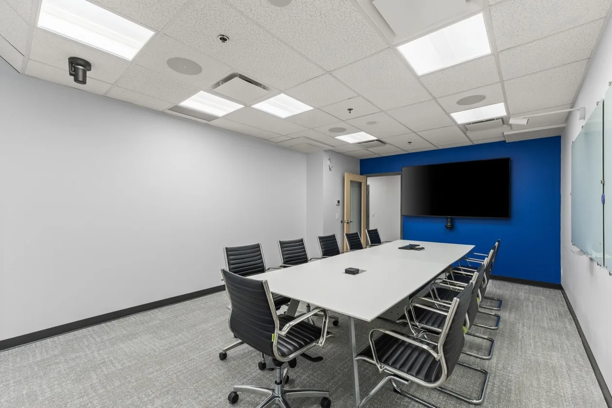Boardroom with blue accent wall and wall-mounted display