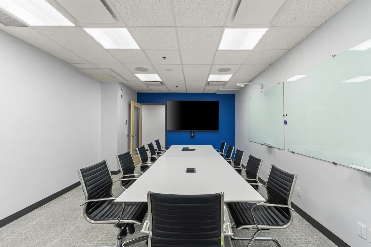 Boardroom with long table, wall display and writable wall
