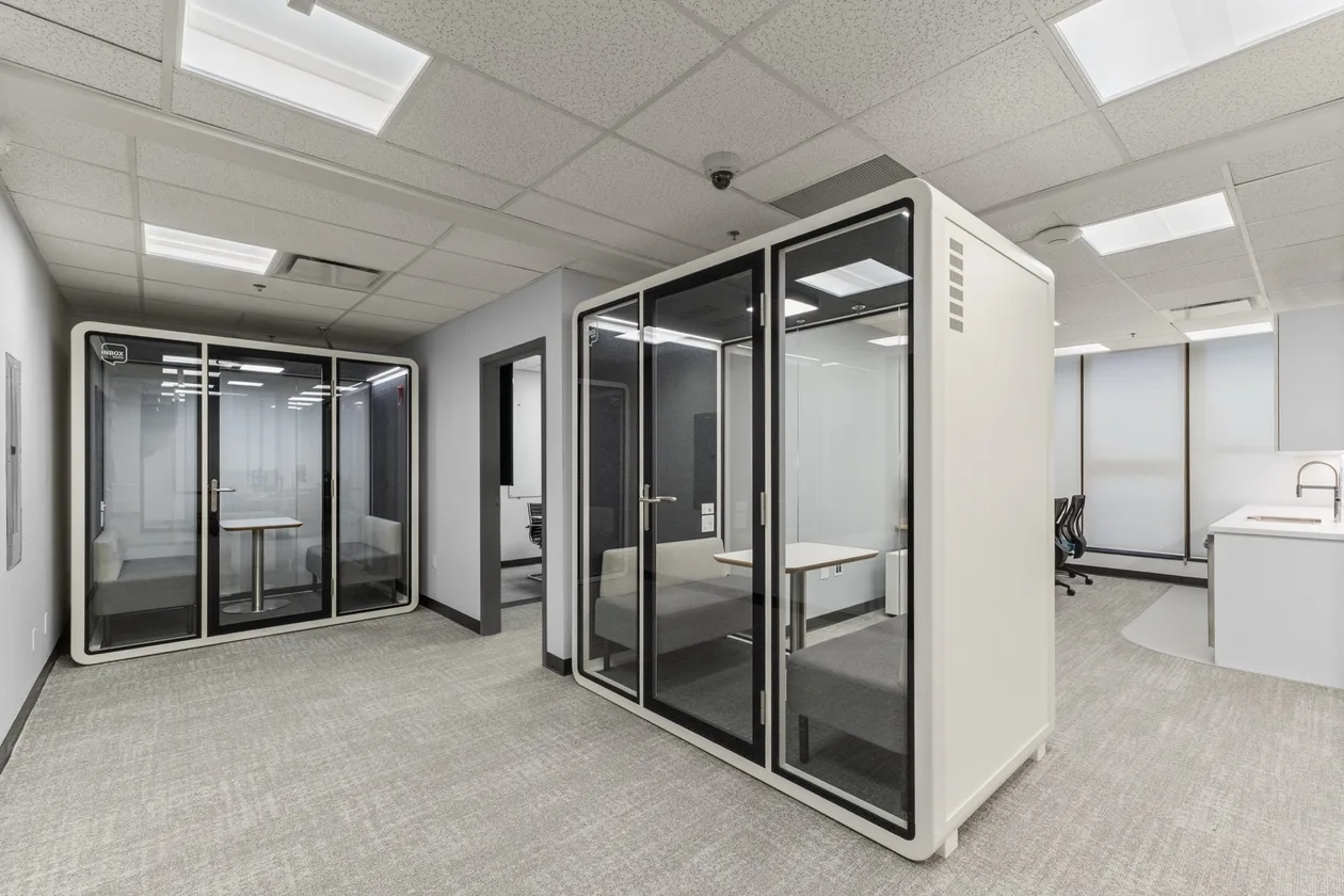 Glass acoustic focus pods in the open office floor