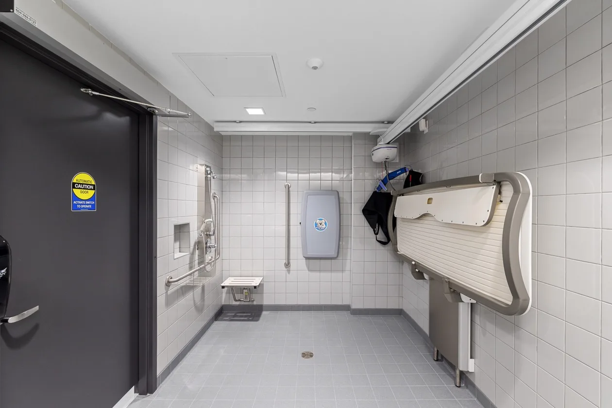 Universal washroom with adult change table and grab bars