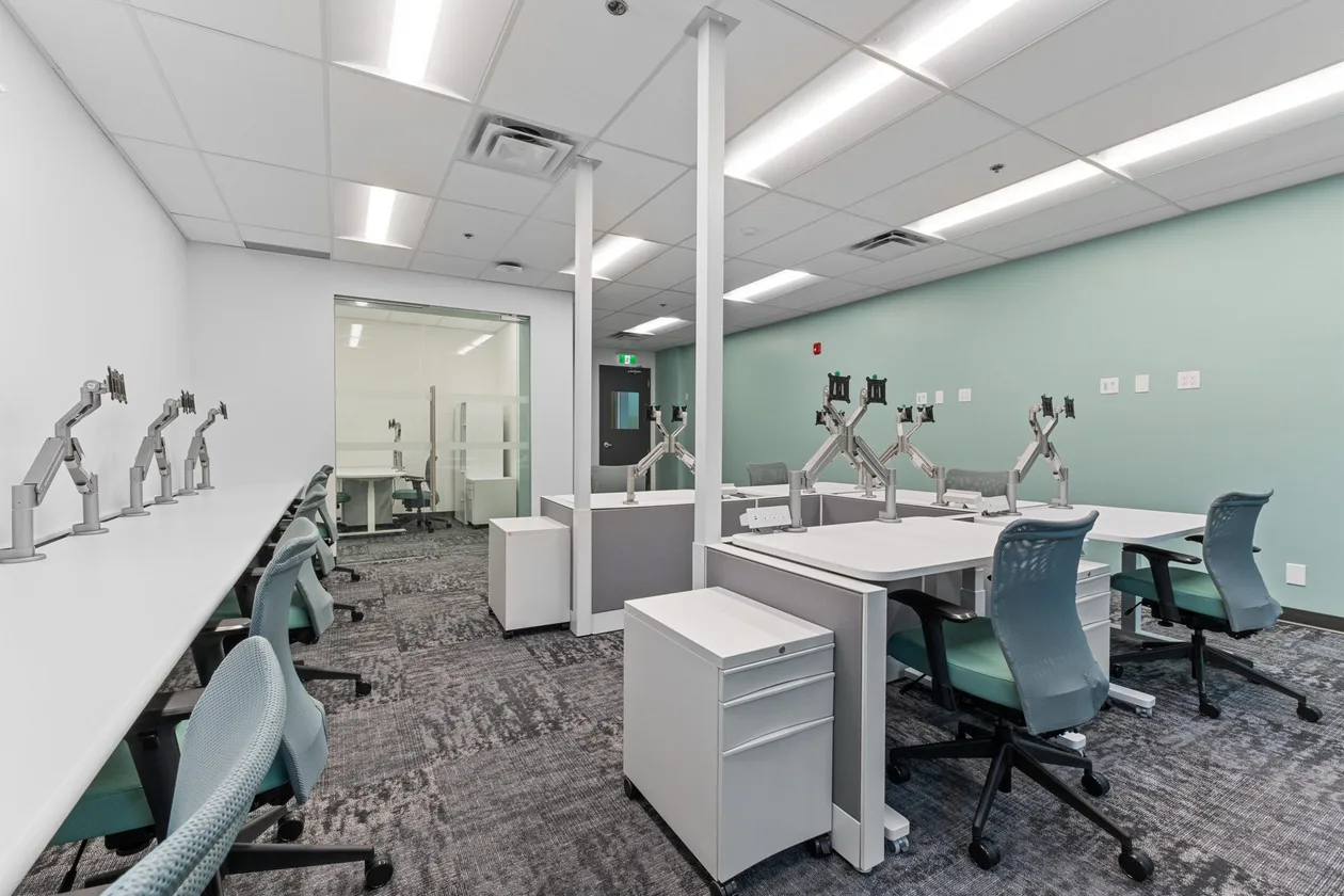 Workstations with storage pedestals and a glazed private office beyond