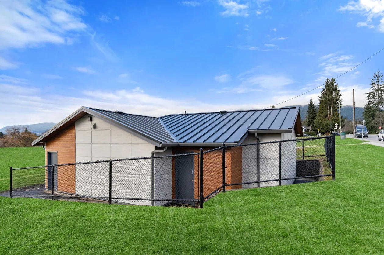 Ray Perrault Fieldhouse envelope renovation in North Vancouver — new cladding and standing-seam metal roof