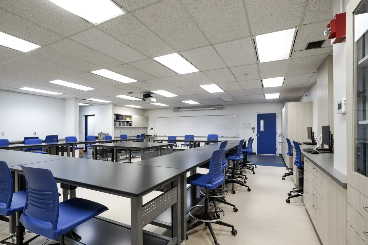 Laboratory with black epoxy bench tops, blue stools and wall casework
