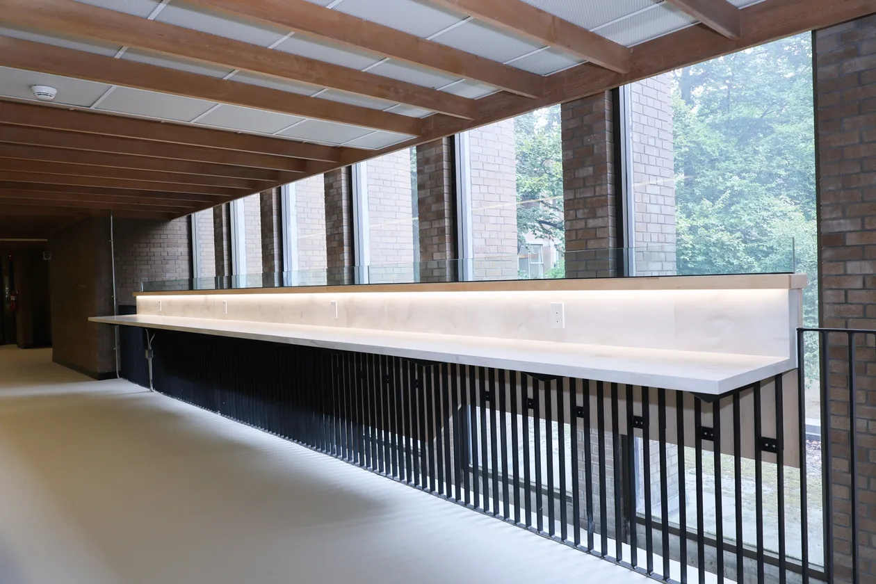 Upgraded mezzanine at UBC’s MacMillan Building — new picket guardrail and lit study counter under a timber ceiling