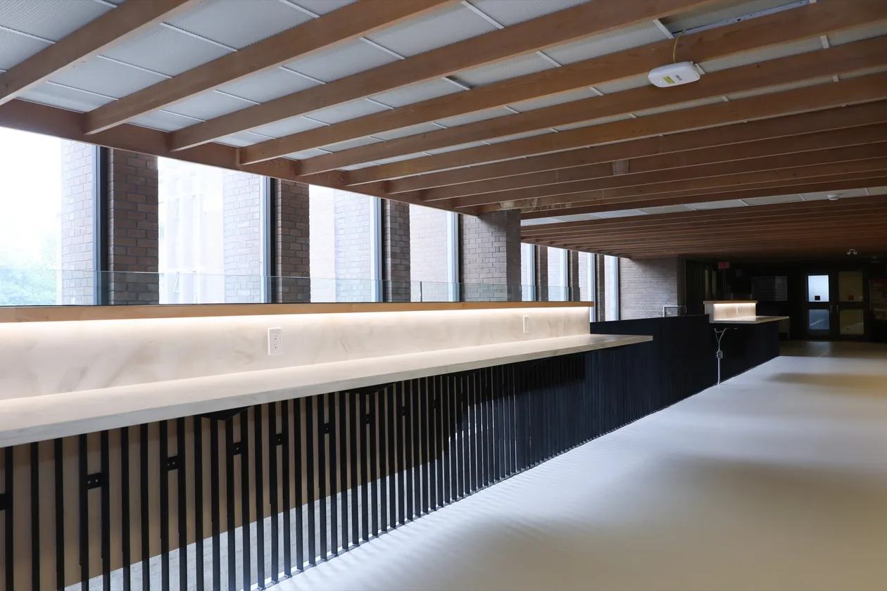 Upgraded second-floor mezzanine looking down its length, with timber ceiling and new picket guardrail.