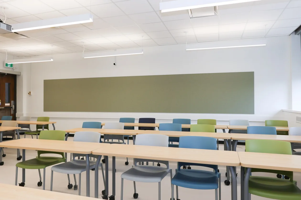 Renovated teaching classroom with new green writing board and seating, UBC MacMillan Building.