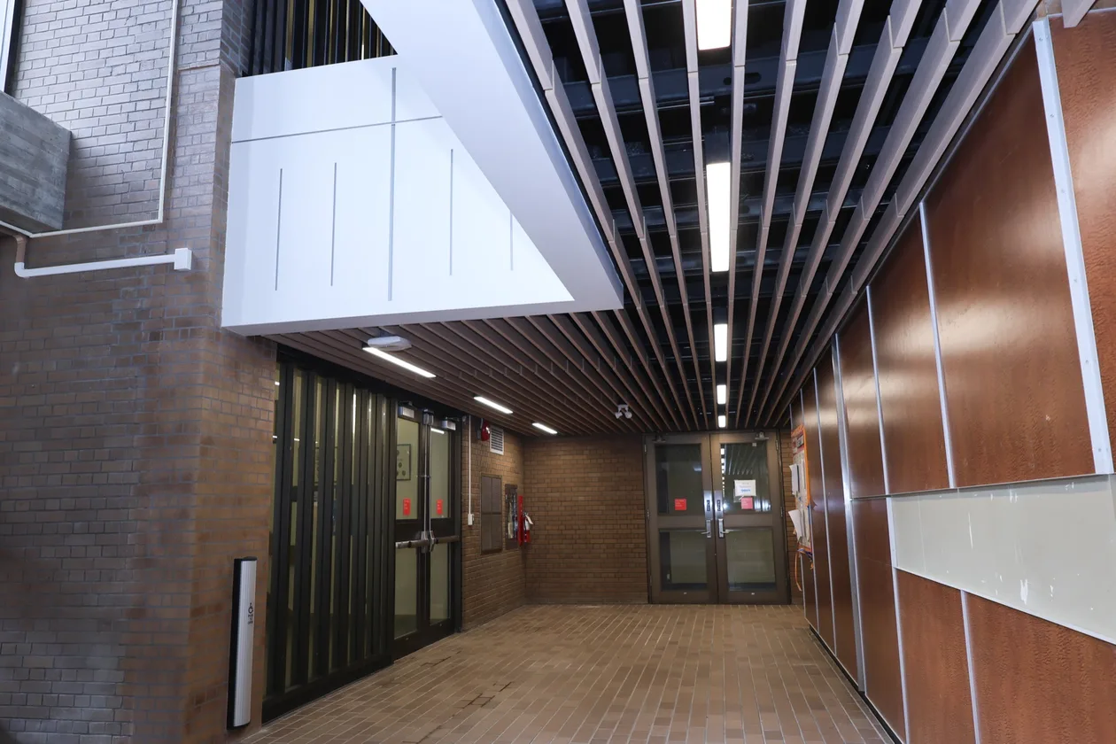 Ground-floor entry at UBC's MacMillan Building with new timber slat ceiling and wood panelling
